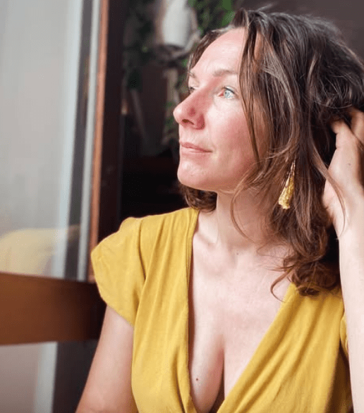 Nina Mae Harper in yellow dress looking pensive